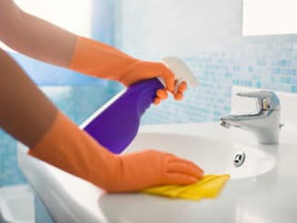 Eine Frau putzt das Waschbecken