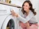 Frau bedient Waschmaschine