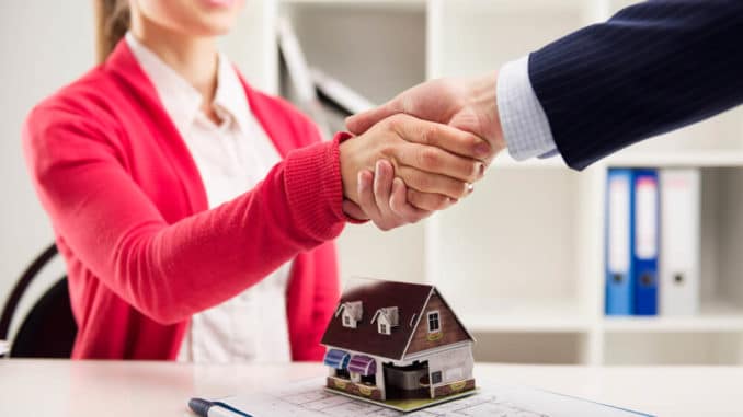 Immobilienmaklerin und Käufer schütteln Hände