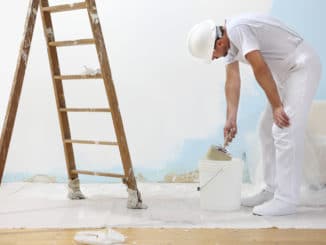 Der Maler streicht eine Wand